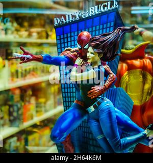 Scultura di spiderman swing via con la sua ragazza amico con Daily Bugle nella goccia posteriore. Foto Stock