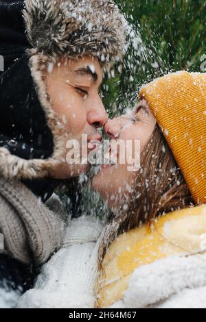 Ritratto emotivo, primi piani, coppia baciare neve sta cadendo su di loro Foto Stock