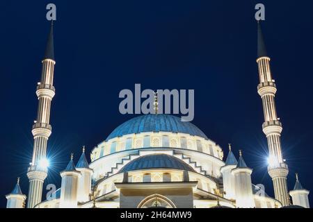 Cupola della moschea "cuore della Cecenia" e due minareti da vicino nell'illuminazione notturna. Grozny, Repubblica cecena Foto Stock