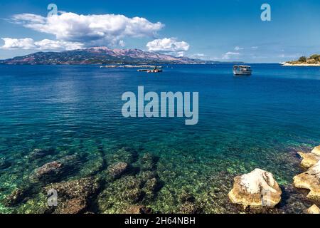 Barca da pesca e fattoria di pesce, vista dalla costa albanese a Corfù, Grecia. Bellissimo paesaggio del mare Ionio. Foto Stock