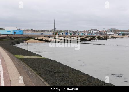 30 Agosto 2021 - Essex, UK: Immagine della costa con frangiflutti e capanne Foto Stock