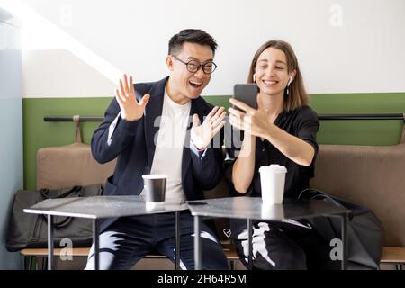 Coppia che effettua videochiamate sullo smartphone in un bar Foto Stock
