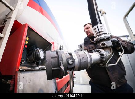 Itzehoe, Germania. 9 novembre 2021. Un dipendente di un'azienda di gasolio e olio di riscaldamento è in possesso di un bocchettone di rifornimento per riempire il suo camion cisterna sulla proprietà dell'azienda. Credit: Christian Charisius/dpa/Alamy Live News Foto Stock