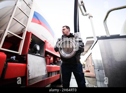 Itzehoe, Germania. 9 novembre 2021. Un dipendente di un'azienda di gasolio e olio di riscaldamento è in possesso di un bocchettone di rifornimento per riempire il suo camion cisterna sulla proprietà dell'azienda. Credit: Christian Charisius/dpa/Alamy Live News Foto Stock