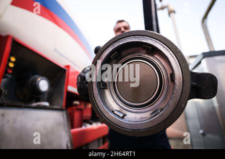 Itzehoe, Germania. 9 novembre 2021. Un dipendente di un'azienda di gasolio e olio di riscaldamento è in possesso di un bocchettone di rifornimento per riempire il suo camion cisterna sulla proprietà dell'azienda. Credit: Christian Charisius/dpa/Alamy Live News Foto Stock