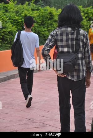 Indietro Visualizza l'intera lunghezza di due ragazzi che camminano all'aperto Foto Stock