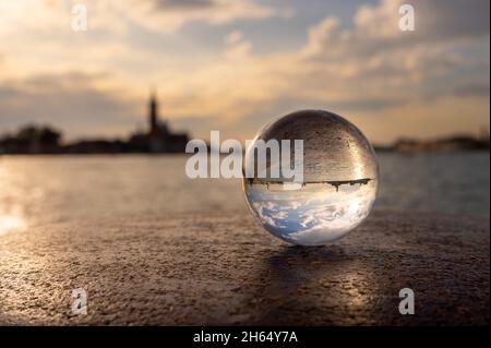 Palla di vetro adagiata su un palude a Venezia (Italia), tramonto vicino al mare Foto Stock