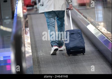 08 novembre 2021, Hessen, Francoforte sul meno: Un viaggiatore sta portando una valigia all'aeroporto di Francoforte Foto: Sebastian Gollnow/dpa Foto Stock