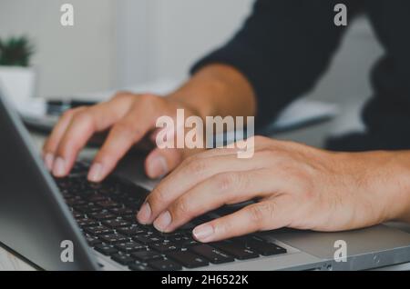 Mano dell'uomo che usa la tastiera del computer portatile. Cerca in internet, informazioni, social networks.Businesses che commerciano acquisti online. Foto Stock