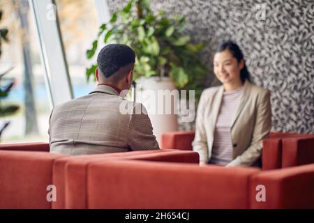 Donna d'affari intervistando giovane maschio candidato di lavoro Foto Stock