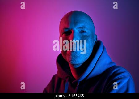 Ritratto illuminato di illuminazione al neon. Uomo di mezza età riuscito e determinato. Foto Stock