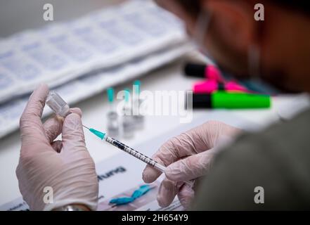 Osnabruck, Germania. 13 Nov 2021. 13 novembre 2021, bassa Sassonia, Osnabrück: Un dipendente della campagna di vaccinazione prepara le dosi di Biontech. Le vaccinazioni sono effettuate nel OsnabrückHalle con vaccini di Biontech e Johnson & Johnson. Foto: Lino Mirgeler/dpa Credit: dpa Picture Alliance/Alamy Live News Foto Stock