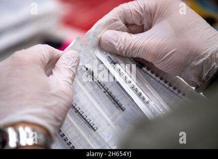 Osnabruck, Germania. 13 Nov 2021. 13 novembre 2021, bassa Sassonia, Osnabrück: Un dipendente della campagna di vaccinazione prepara le dosi di Biontech. Le vaccinazioni sono effettuate nel OsnabrückHalle con vaccini di Biontech e Johnson & Johnson. Foto: Lino Mirgeler/dpa Credit: dpa Picture Alliance/Alamy Live News Foto Stock