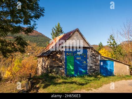 Attraenti porte fienile dipinte a mano su un edificio in pietra nella gola del Tarn che fa pubblicità a un negozio di fattoria locale Foto Stock