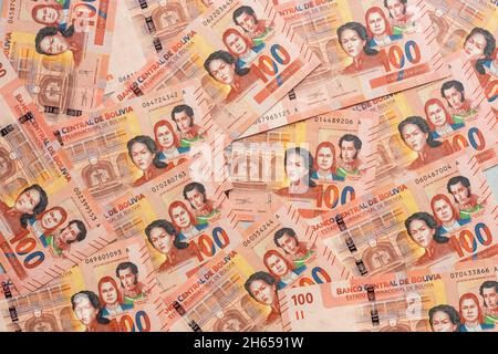 Denaro boliviano, un sacco di 100 banconote bolivianiche sparse sul tavolo, riempito di una cornice Foto Stock