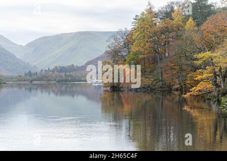 Vista di Ullswater nel Lake District a Cumbria, Inghilterra, Regno Unito, in una tranquilla mattina presto di novembre. Splendido paesaggio lacustre con colori autunnali. Foto Stock