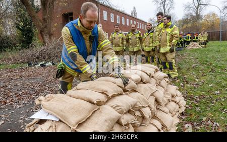 Neumunster, Germania. 13 Nov 2021. 13 novembre 2021, Schleswig-Holstein, Neumünster: Vigili del fuoco del Dipartimento del fuoco di Garding Volunteer pratica passando e impilando sacchi di sabbia in un modo che è facile sul corpo. Questo non fa normalmente parte del loro addestramento, poichè il controllo di disastro e la difesa di dike sono compiti del THW (Technisches Hilfwerk). In futuro, tuttavia, il Dipartimento dei vigili del fuoco di Garding vuole anche essere pronto per eventuali inondazioni. Foto: Markus Scholz/dpa Credit: dpa Picture Alliance/Alamy Live News Foto Stock