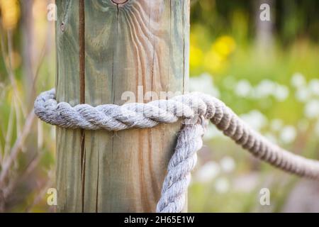 Recinzione in corda e palo in legno nel parco pubblico Foto Stock
