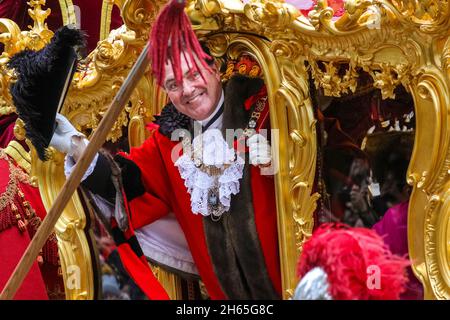 Londra, Regno Unito. 13 Nov 2021. Il nuovo sindaco del Signore ondeggia dalla vettura di stato d'oro. L'annuale Lord Mayor's Show, una processione attraverso la città di Londra che ha più di 800 anni, e quest'anno ospita diverse migliaia di allegri partecipanti, si fa strada da Mansion House, via St Paul, alle corti reali di giustizia. Alderman Vincent Keaveny è stato eletto come il 693 Signore Sindaco della città di Londra. Credit: Imagplotter/Alamy Live News Foto Stock