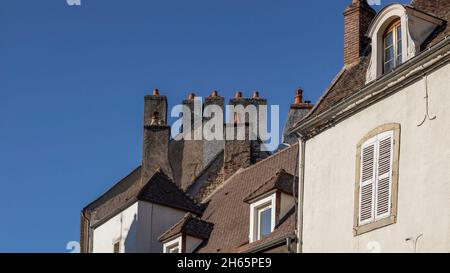Camini multipli le cime del tetto di una città francese Foto Stock