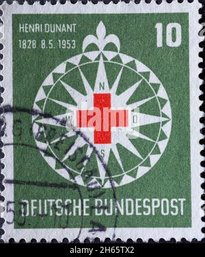 GERMANIA - CIRCA 1953:su questo timbro postale stampato in Germania, si può vedere il simbolo della Croce Rossa in una rosa stilizzata vento. Lo sfondo è verde Foto Stock