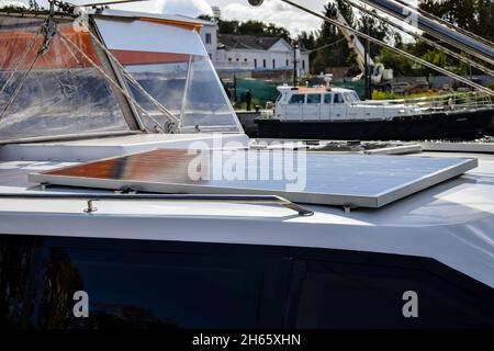 Pannello solare montato sulla prua di un piccolo yacht. Parcheggio al molo. Primo piano. Messa a fuoco selettiva. Spazio di copia. Foto Stock