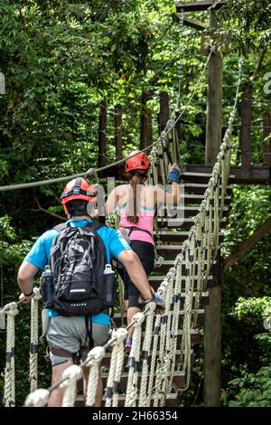 Coppia attraversando ponte sospeso baldacchino, Ecoquest Adventures & Tours, Hacienda campo Rico, Carolina, Porto Rico Foto Stock