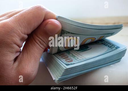 Mano dell'uomo del primo piano che tiene le fatture del dollaro. Conteggio delle banconote in denaro. Foto Stock