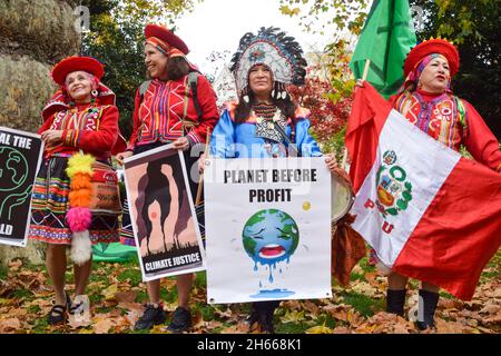 Londra, Regno Unito. 13 novembre 2021. I manifestanti che indossano abiti indigeni tengono dei cartelli presso il Lincoln's Inn Fields. Estinzione i manifestanti della ribellione marciarono attraverso la città di Londra, interrompendo lo spettacolo del Signore Sindaco per protestare contro il 'fallimento' della COP26. Credit: Vuk Valcic / Alamy Live News Foto Stock