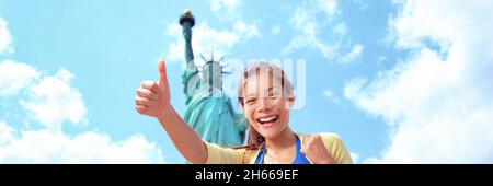 New York City turista donna alla Statua della libertà felice di fare i pollici su banner panorama. Ragazza asiatica sul viaggio di vacanza degli Stati Uniti. Giovane donna multirazziale Foto Stock