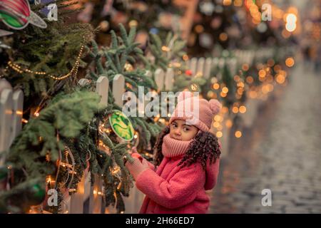 Una bambina di 5 anni cammina per le strade alla vigilia della festa di Capodanno Foto Stock