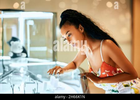 Shopping. Bella giovane donna asiatica guardando gioielli in vetrina durante lo shopping Foto Stock