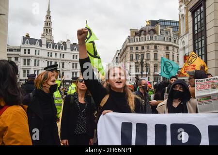 Londra, Regno Unito. 13 Nov 2021. Un dimostratore si aggredisca mentre cantava slogan durante la protesta.i dimostranti della ribellione di estinzione marciarono attraverso la città, interrompendo lo spettacolo del Signore Sindaco per protestare contro il 'fallimento' della conferenza COP26 sul cambiamento climatico. Il Lord Mayor's Show è una sfilata pubblica che segna l'inaugurazione del nuovo Lord Mayor della City di Londra, il quartiere finanziario della capitale. Credit: SOPA Images Limited/Alamy Live News Foto Stock