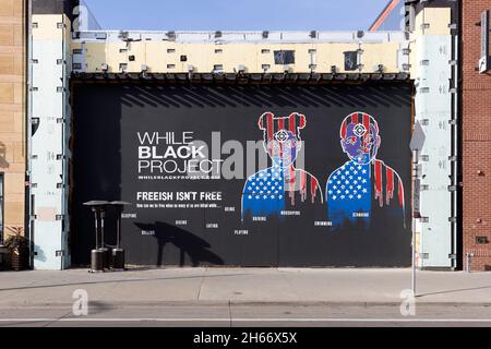 Mentre Black Project murale di Cadex Herrera con due giovani con obiettivi di vista pistola sulla fronte che illustrano i pericoli per le persone di Foto Stock