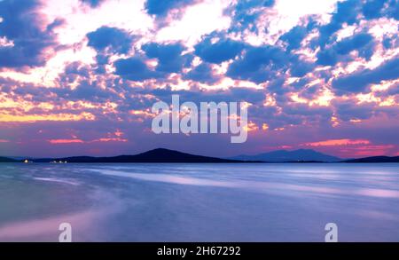 Foto a lunga esposizione di paesaggi marini e nuvolosi dalla costa di Ayvalik dopo il tramonto. Foto Stock