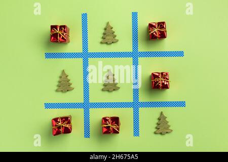 Anno nuovo tic tac toe gioco, isolato su sfondo verde. Natale, concetto d'inverno. Appartamento laico, vista dall'alto. Foto Stock