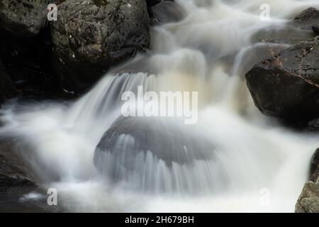 Primo piano di una cascata con acqua che precipita su massi, Regno Unito Foto Stock