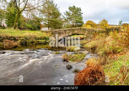 Passerella in pietra sopra Watendlath Beck a Watendlath Tarn nel Lake District in Cumbria, Inghilterra Foto Stock