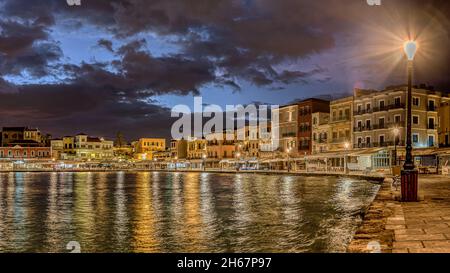 Vecchio porto veneziano di Chania di notte con riflessi colorati nella baia da una lampada di strada incandescente, Chania, Creta, Grecia, ottobre 13, 2021 Foto Stock