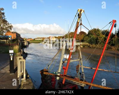 Un peschereccio e altre imbarcazioni ormeggiate sul fiume Haven con case sullo sfondo durante l’autunno nel Lincolnshire DI BOSTON, Foto Stock