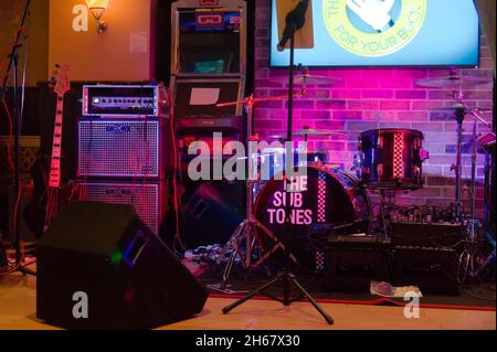 Drumkit, amp e altri attrezzi sul palco presso l'Anchor Inn pub appartenente alla Sub Tomes (band) Foto Stock