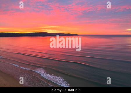 Colorata alba coperta da nuvole a Umina Beach sulla costa centrale, NSW, Australia. Foto Stock