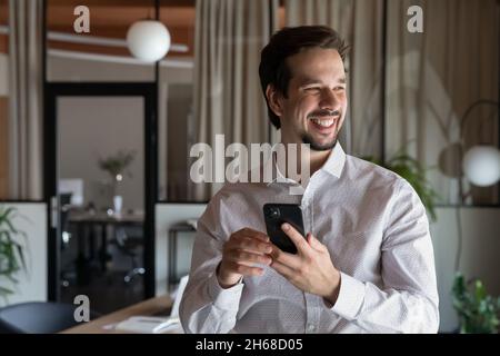 Felice giovane uomo d'affari ispanico manager con smartphone. Foto Stock