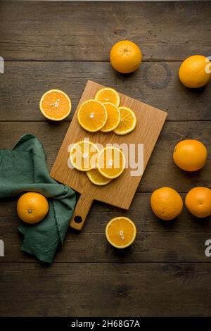Fresche e succose arance vitaminiche su tavola di legno. Agrumi dimezzati. Variazione di mandarino a fette miste. Prodotti vegetariani tropicali esotici colorati Foto Stock