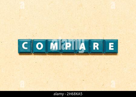 La lettera dell'alfabeto della piastrella in parola confronta su sfondo di legno Foto Stock