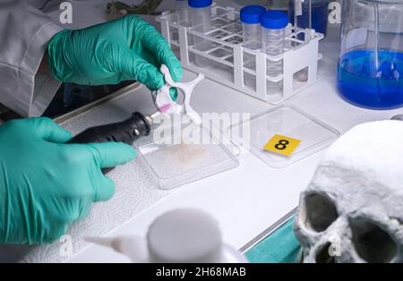 Lo scienziato forense rimuove le ossa dallo scheletro umano per indagare sull'omicidio e prelevare campioni in laboratorio di crimine, immagine concettuale Foto Stock