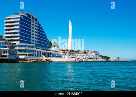 Sevastopol, Crimea, Russia - 11 giugno 2021: Complesso residenziale di Capo Khrustalny e l'obelisco per la città di Eroe di Sevastopol durante la giornata di sole. Sevas Foto Stock