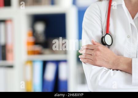 Donna medico in uniforme ha piegato le braccia sul petto Foto Stock