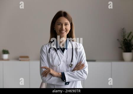 Testa ritratto sorridente medico terapista con braccia incrociate Foto Stock