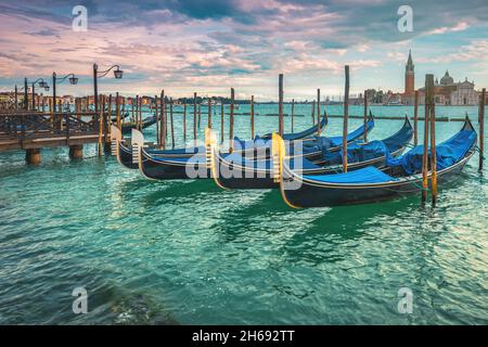 Famosa destinazione turistica e turistica con gondole ormeggiate sul lungomare di Venezia, Italia, Europa Foto Stock